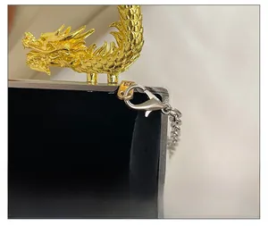 Macro detail of golden dragon handle and silver chain on an acrylic box bag