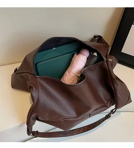Detailed view of the spacious interior of a brown tote bag with zipper and gadgets