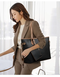 Detail der schwarzen Shopper-Tasche mit braunen Riemen und passendem kleinem Etui