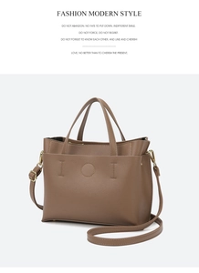 Detail of a brown lychee pattern leather tote bag featuring gold hardware and minimalist stitching