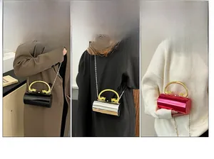 Three variants of cylindrical acrylic bags with golden dragon handles and chain straps