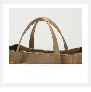 Macro shot of brown pebble grain leather tote bag with gold zipper and stitching details