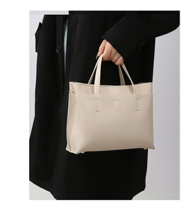 Detail of off-white tote bag featuring lychee grain texture and IOI decorative stitching