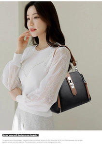 Detail of black lychee grain leather bucket bag with brown strap on model