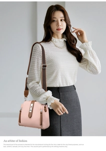 Detail of pink pebbled leather bucket bag with brown canvas strap and metal clasp