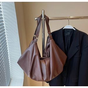 Detail of dark brown tote bag featuring pebbled faux leather and spacious interior