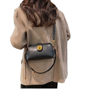 Retro black leather doctor crossbody bag with gold metal clasp shown on a model