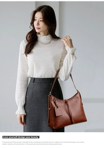 Close-up of brown vintage leather handbag featuring tassel and smooth textured finish