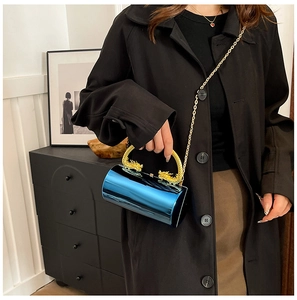 Detailed close-up of blue metallic cylindrical clutch with gold dragon handles
