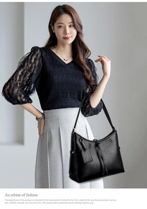 Detail of black pebbled leather tote bag featuring elegant tassels and a leather hangtag