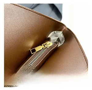 Detail of premium gold metal zipper and herringbone fabric lining on dark brown tote bag