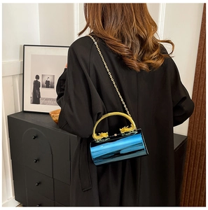 Detail of blue cylindrical evening bag with gold dragon-shaped handle and chain strap