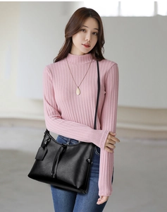 Fashionable black matte leather shoulder bag with drawstring detail shown on model