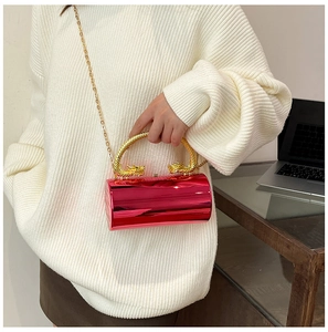 Red cylindrical evening bag featuring golden dragon handles and metallic chain strap