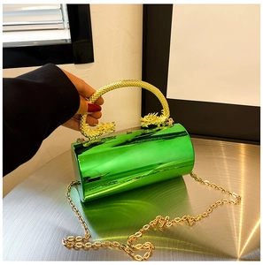 Detail of green acrylic clutch featuring gold dragon-head handle and metallic chain