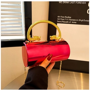 Detail of red cylindrical clutch featuring golden dragon handle and metallic chain strap