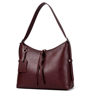Fashionable burgundy leather tote bag with stylish shoulder strap and front knot detail
