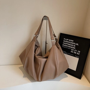 Minimalist coffee leather tote bag with pleated side details and metallic ring connector