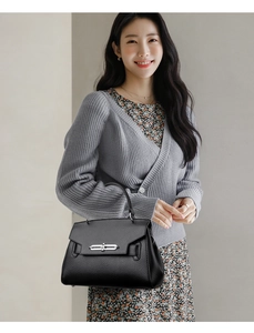 Litchi texture black leather handbag with silver lock shown on model outfit