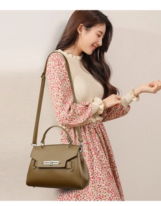 Olive green lychee texture handbag shown on model with adjustable shoulder strap