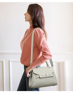 Detail view of the light green lychee grain leather texture and silver buckle on the bag