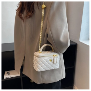 Close-up of a white quilted leather mini bag featuring gold chain and metal handle