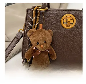 Détail d'un charm de sac ours en peluche marron avec ruban Love sur un sac à main