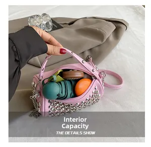 Interior capacity of pink cylinder bag showing storage for umbrella and makeup accessories