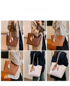Primo piano di borse tote intrecciate in marrone e kaki con sciarpa di seta decorativa