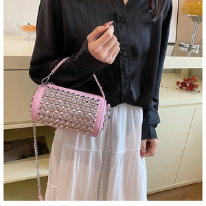 Pink rhinestone cylinder bag with metallic studs and a detachable silver chain strap