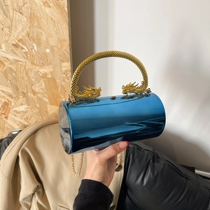 Cylindrical evening bag with metallic blue finish and golden dragon-shaped handle accessory