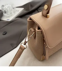 Detailed macro view of beige woven leather bag with premium gold hardware and zipper