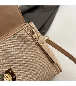 Detailed close-up of beige woven texture bag with gold twist lock and zipper details