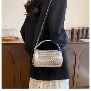 Detail of silver cylindrical bag with rhinestones and elegant metal chain strap