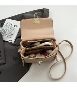Detailed view of the organized multi-compartment interior of this beige leather handbag
