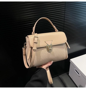 Detail of beige faux leather and fabric shoulder bag with golden triangle twist lock