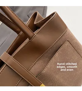 Detail of caramel brown tote bag featuring dual leather textures and expert stitching