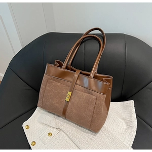 Detail of vintage brown tote bag featuring suede texture and gold metallic twist lock
