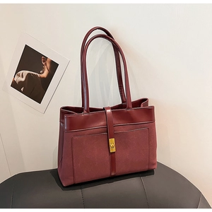 Detail of burgundy tote bag with matte texture and golden square twist lock buckle