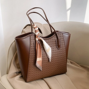 Grande borsa tote marrone con trama intrecciata e foulard di seta alla moda su sedile