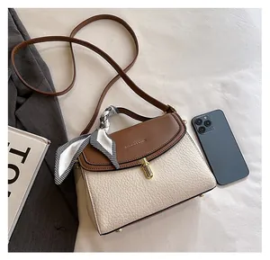 Top view of cream and brown crossbody bag with scarf handle and phone for size comparison
