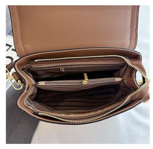 Detailed interior of brown crossbody bag showing striped lining and multi-compartment design