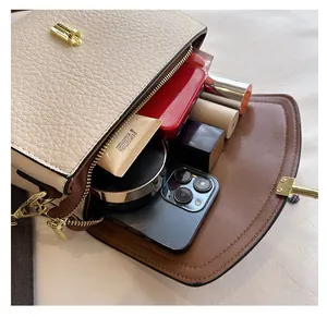 Interior detail of two-tone crossbody bag showing large capacity for phone and cosmetics