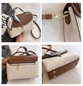 Detail view of bicolor crossbody bag showing gold lock, silk scarf handle and back pocket