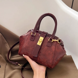 Deep red crocodile embossed handbag with gold hardware and adjustable strap