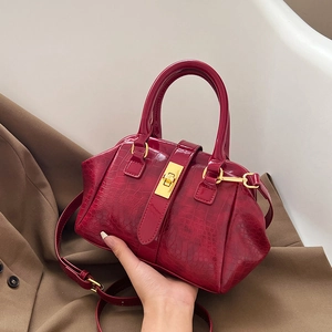 Glossy red crocodile embossed handbag with gold turn-lock and adjustable shoulder strap