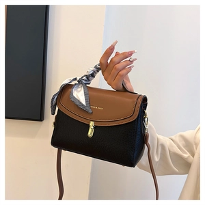 Detail of color-block leather crossbody bag with gold lock and checkered scarf handle
