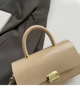 Détail du sac à main carré beige minimaliste en cuir lisse avec une boucle en métal doré