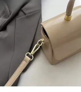 Détails de la boucle dorée et des coutures sur un sac à main en cuir beige