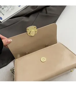 Détail du sac carré beige avec fermoir magnétique doré et cuir de qualité supérieure